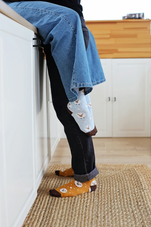 an elderly person standing next to a cabinet with her feet in the cabinets