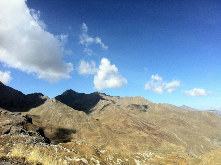 the mountains are covered with grass and bushes