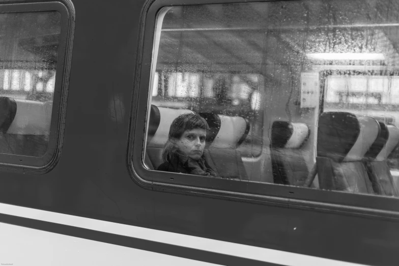two people are looking out the window of a subway train