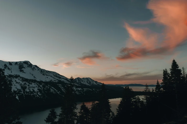 an orange cloud hovers over the top of a mountain