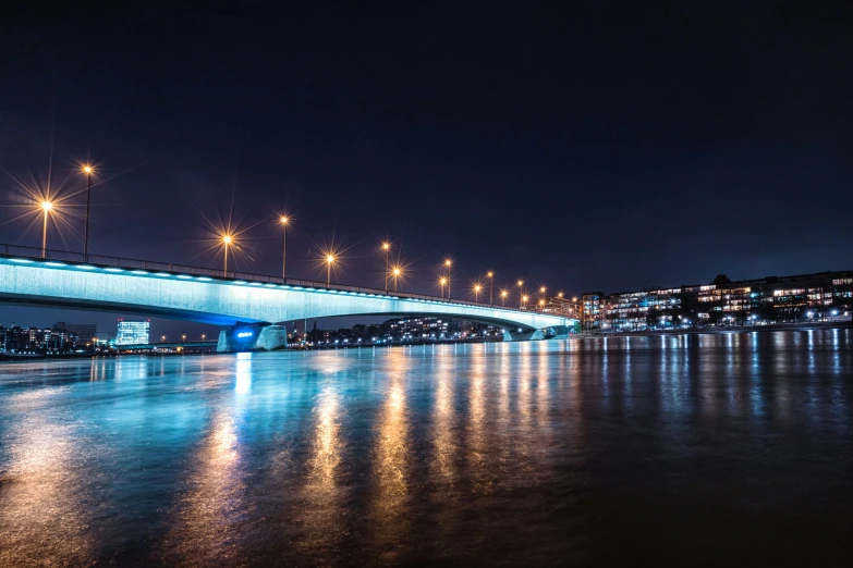 the bridge in the dark has lights reflecting on the water