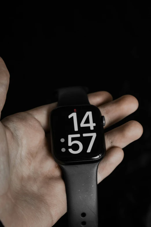 a hand holding onto an apple watch with the time displayed