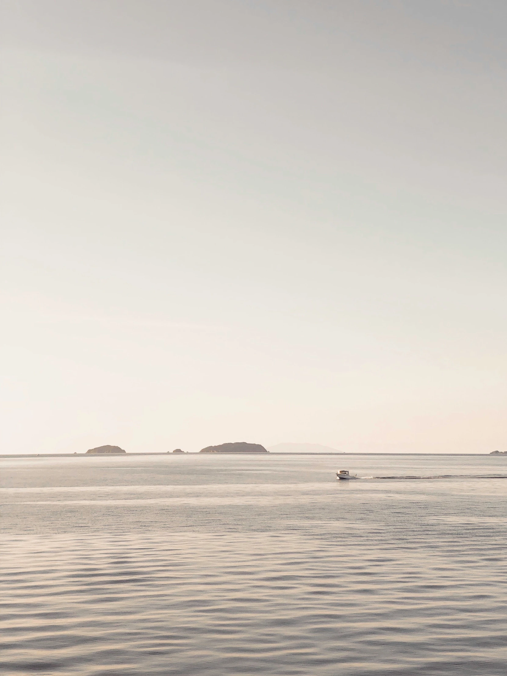 a boat sails through an island filled with a row of small islands