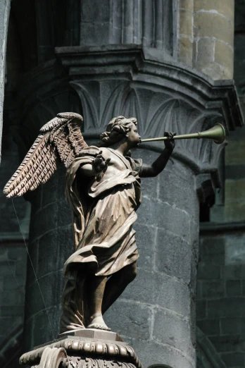 an angel statue in a courtyard near a stone building