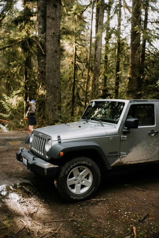 a grey jeep parked on a muddy road