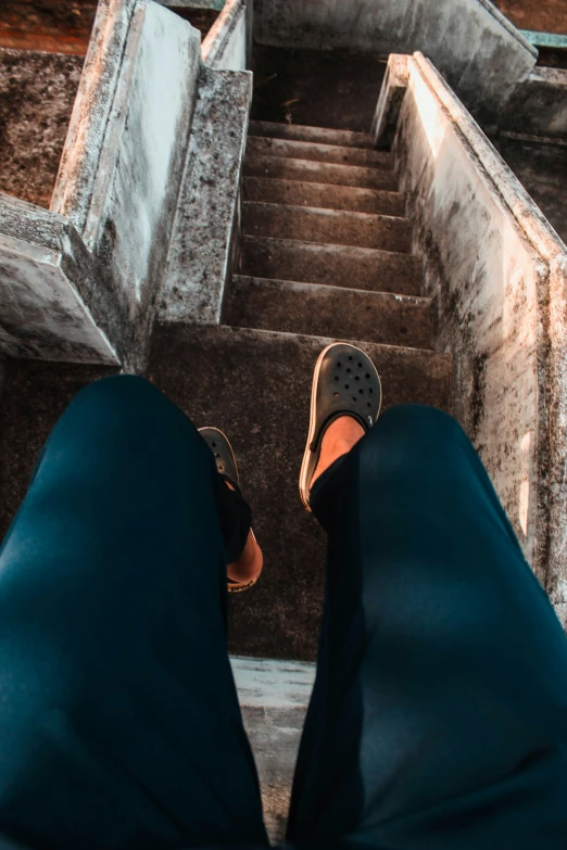 a person's feet in slippers walking down some stairs