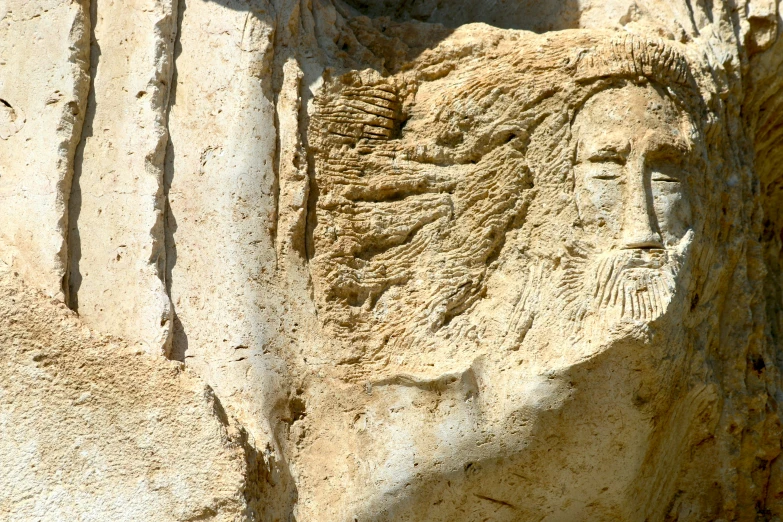 a large stone sculpture of a person's head next to another type of face