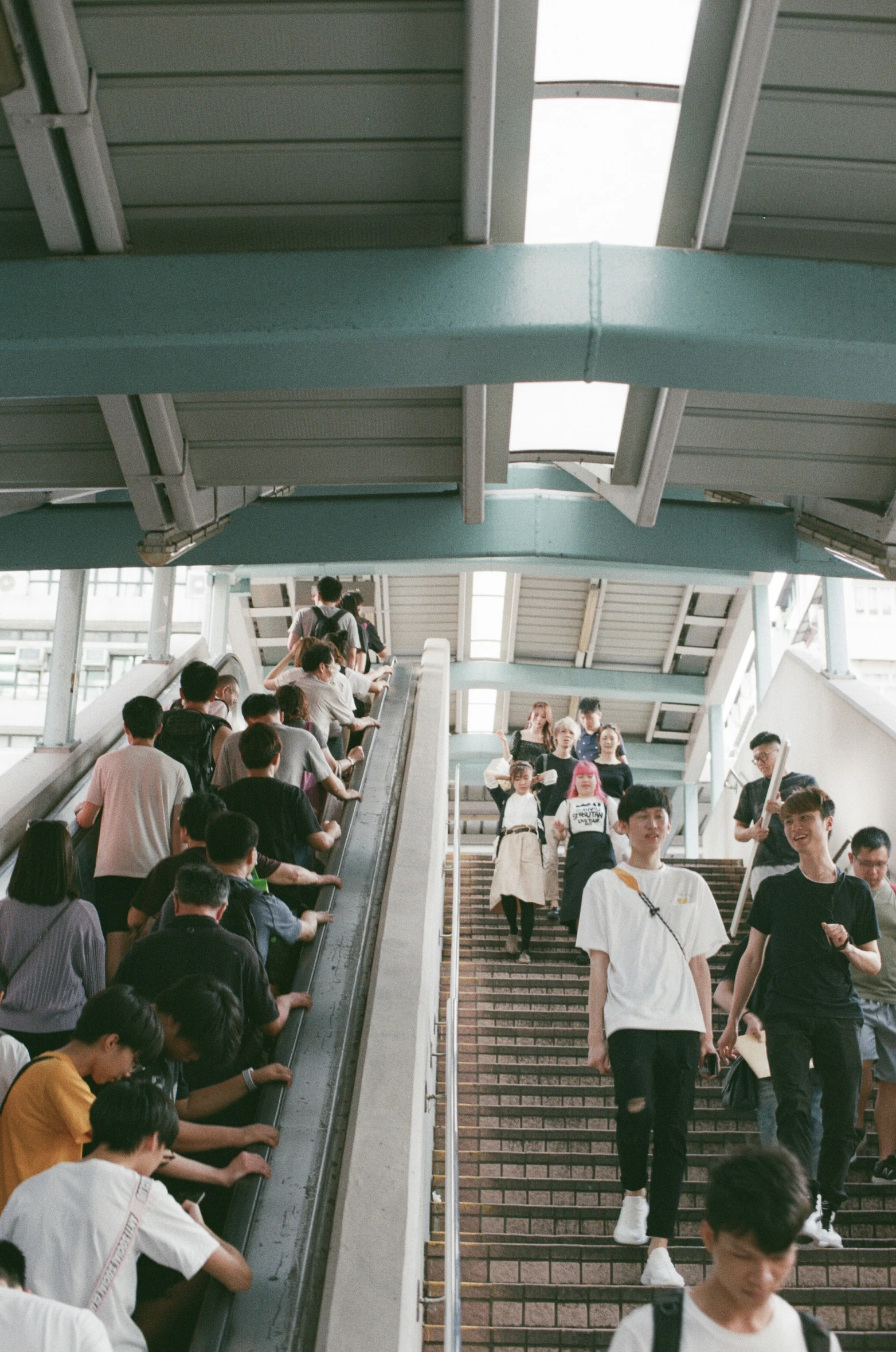 many people are traveling down the stairs in a building