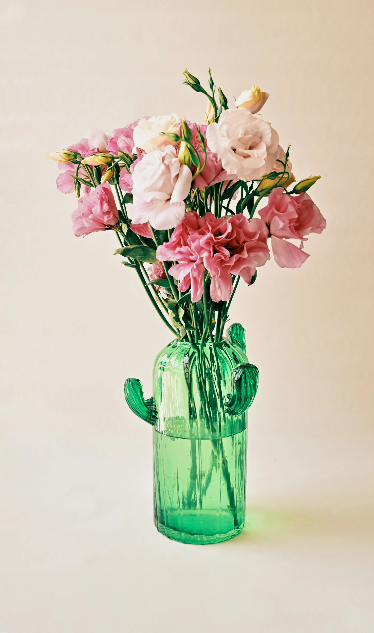 a glass vase filled with pink flowers on a white background