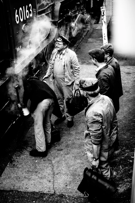 black and white pograph of three people near a train