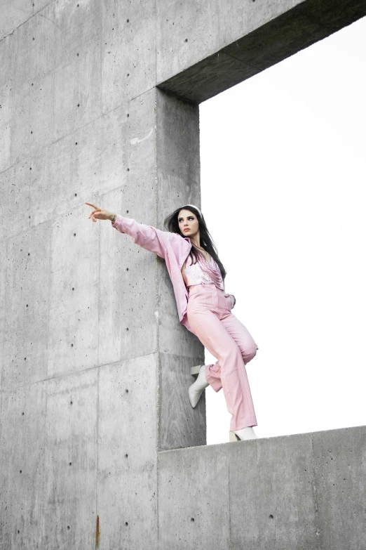 woman posing with outstretched arms near concrete structure