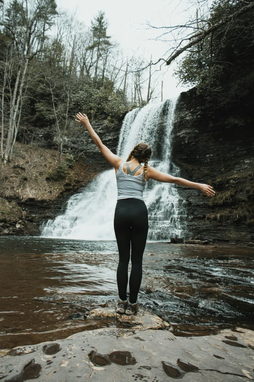 woman standing in front of waterfall in daytime