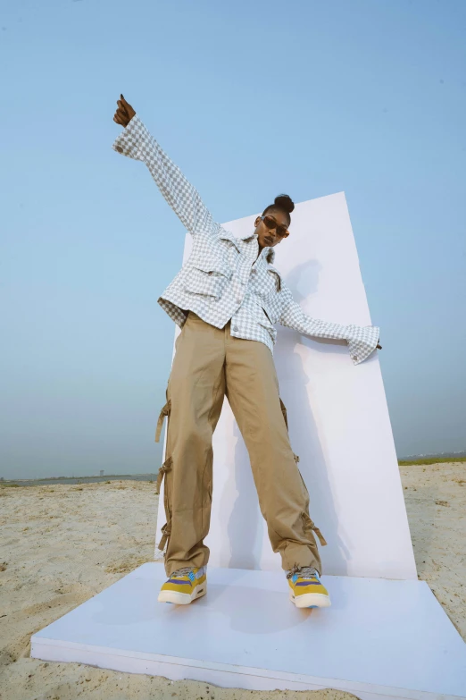 a person that is standing in the sand near a sign