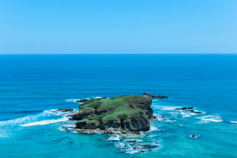 an island surrounded by turquoise blue water on the side of the ocean