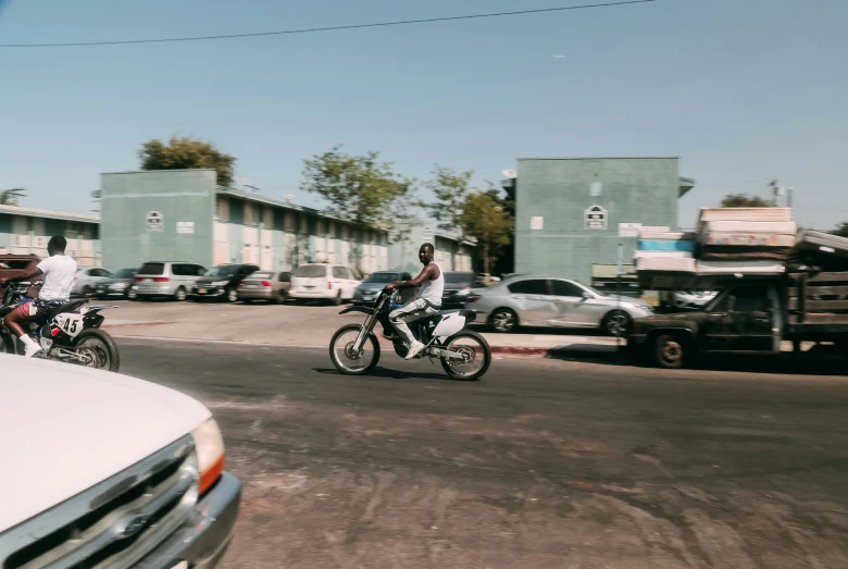 people riding motorcycles down the street with other vehicles