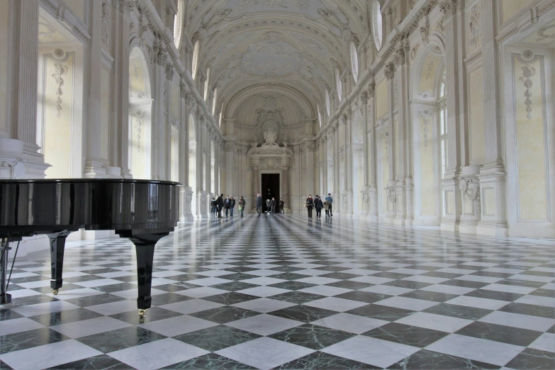 there is a black piano in the middle of an elegant hallway