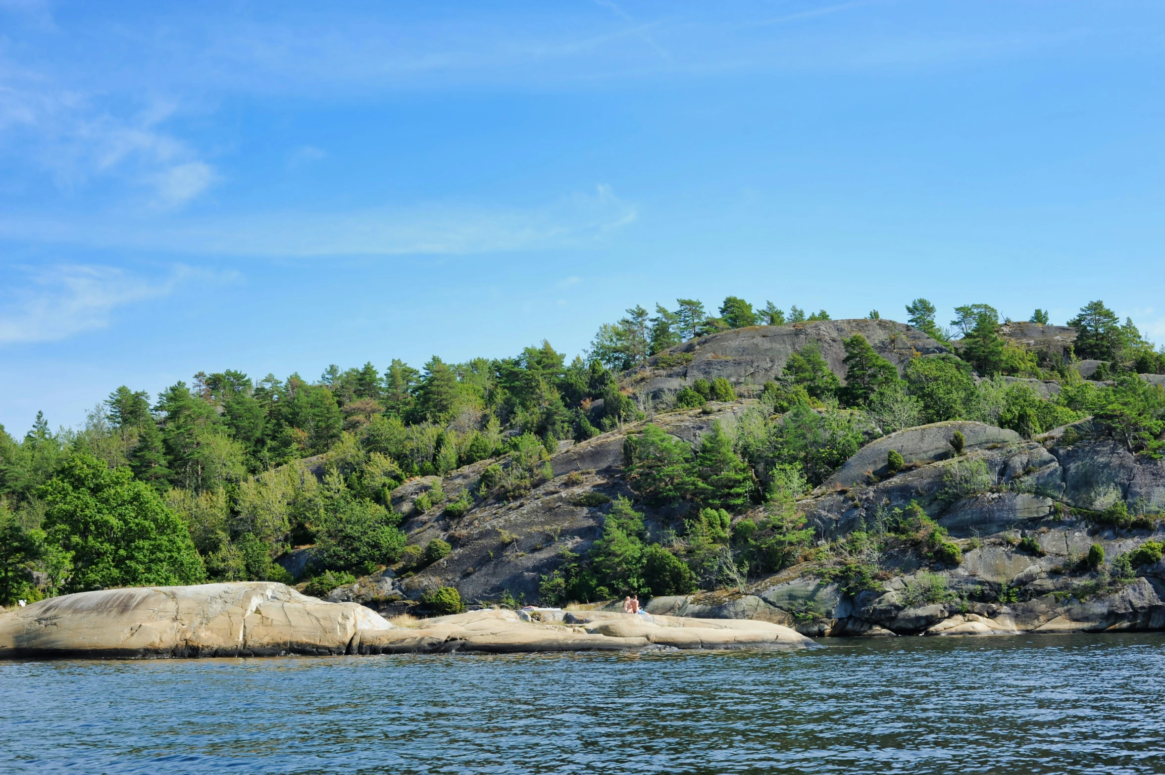 a small island on the edge of a lake surrounded by trees