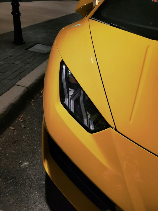 an orange sports car is parked on a city street