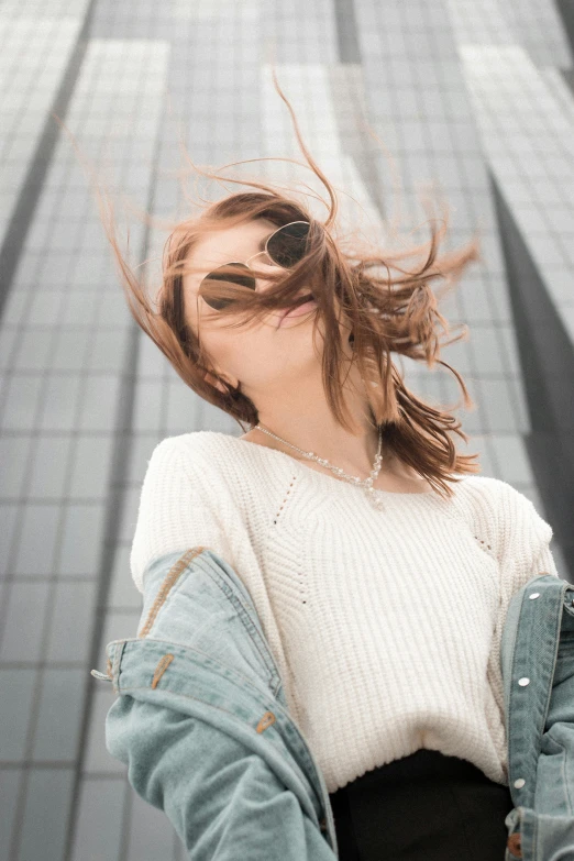 a woman smiling in the wind with her hair up and she is holding her arm out