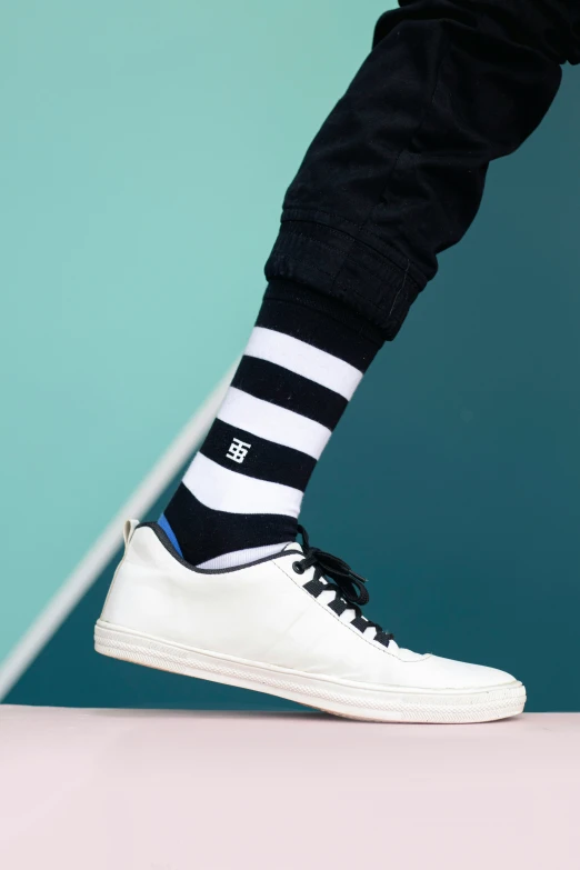 a white shoe with black and white stripes on it