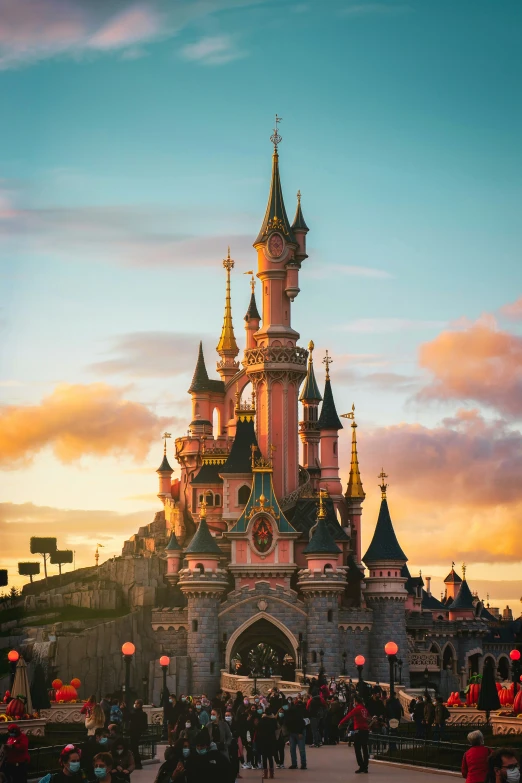 an illuminated pink and gold tower with a sky background