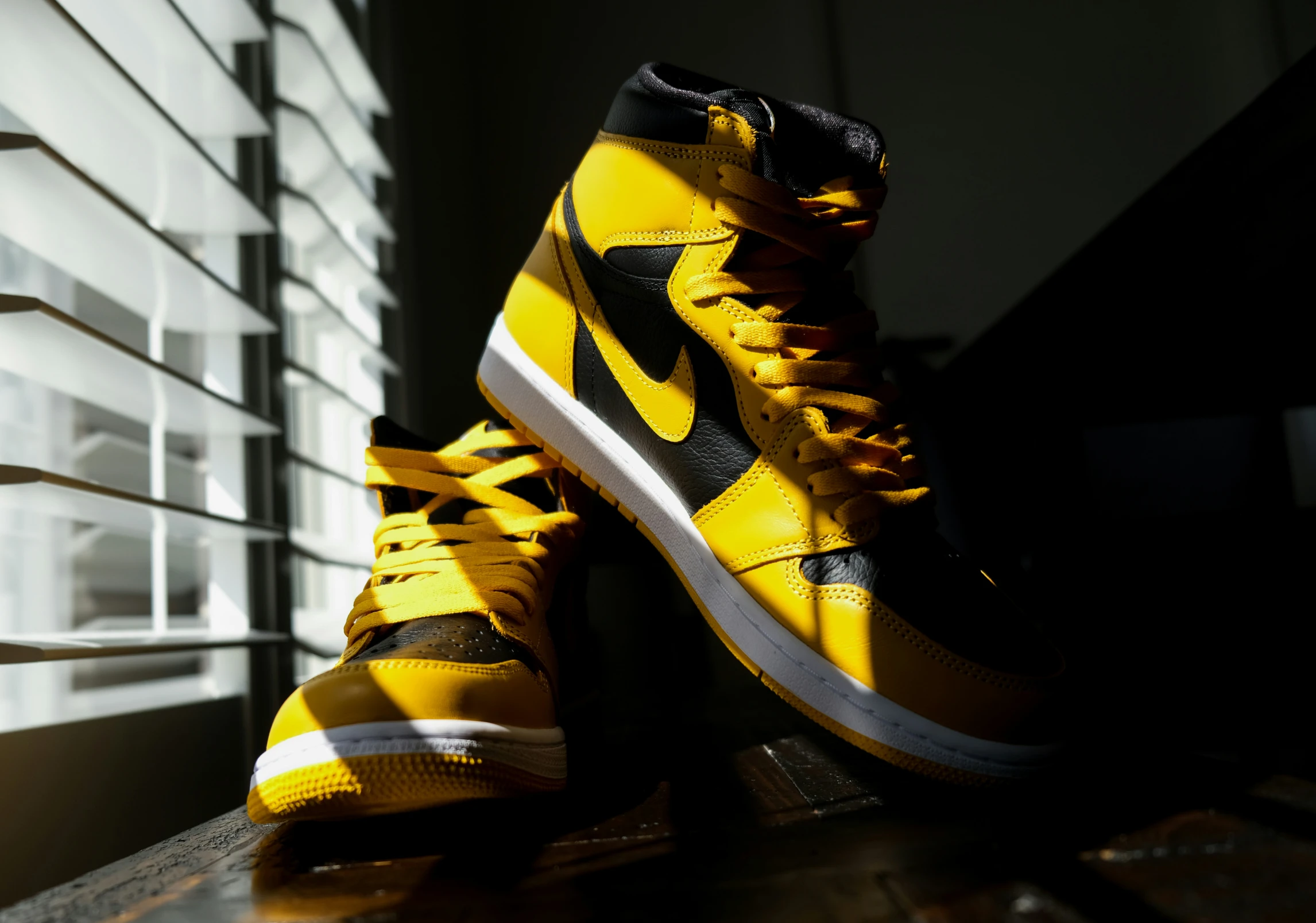 the shoe is black and yellow and the shoes have white and black soles