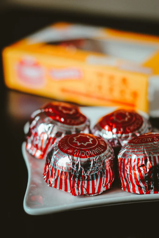 candy with candy wrappers are placed on a white plate