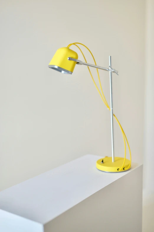 a yellow lamp on the white counter by the wall