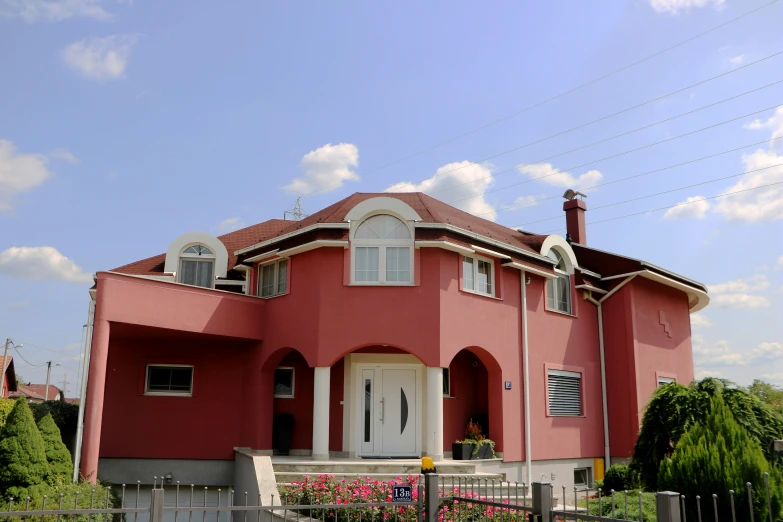 a pink house with white trim on the front