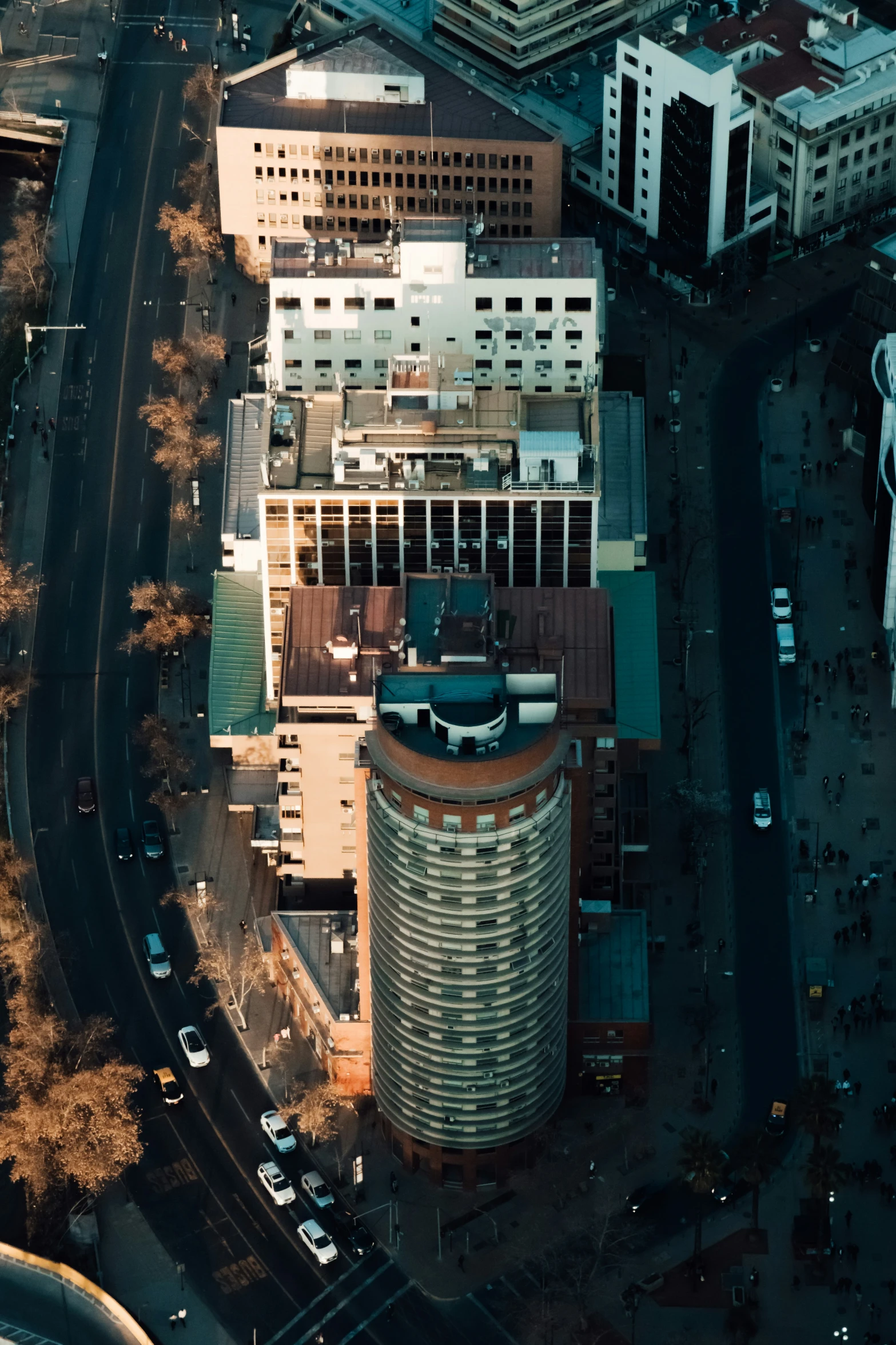 an aerial view of a building, parking lots and cars