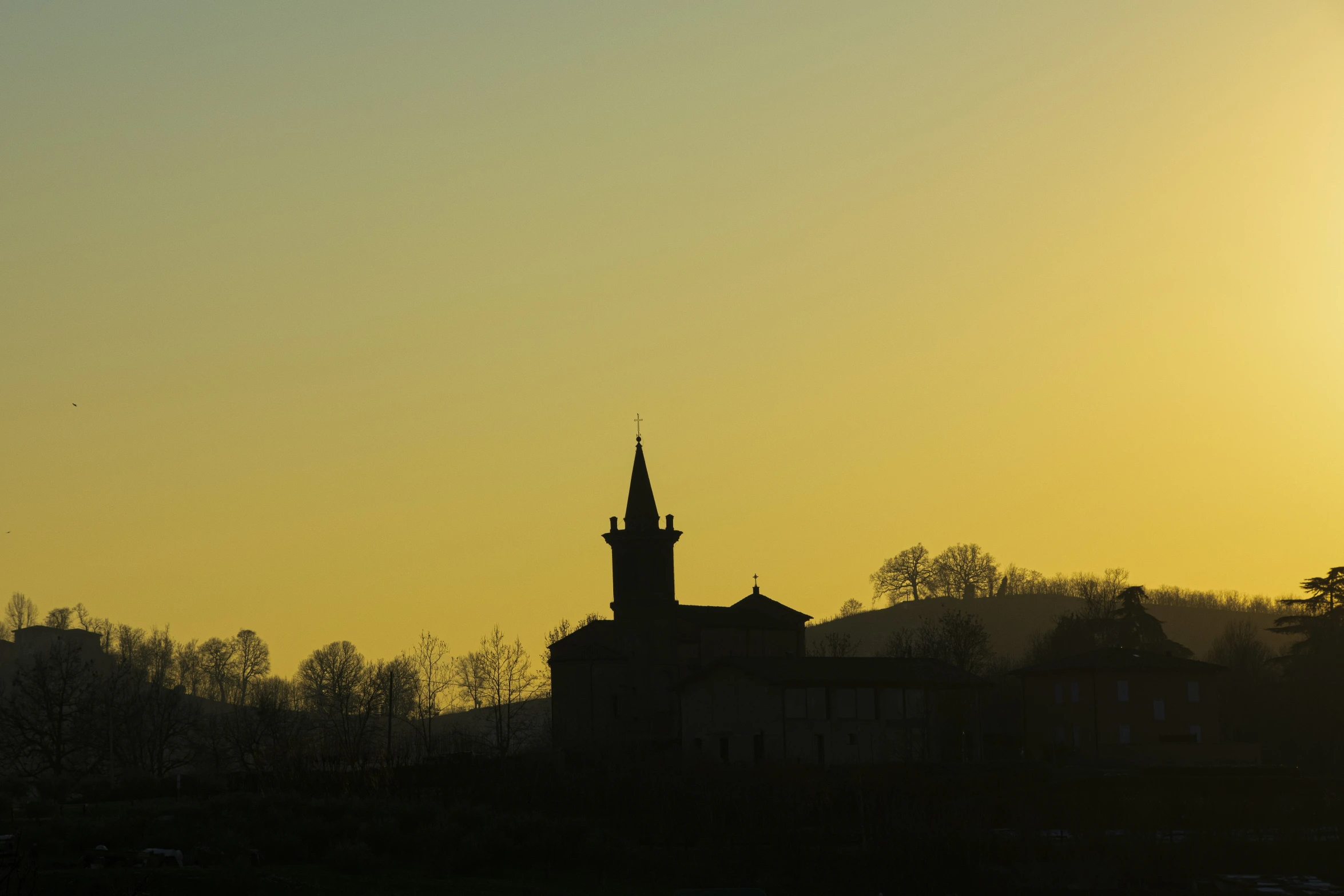 the sun rising above a building with spires