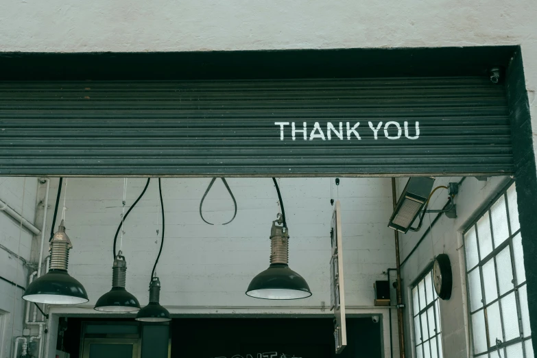a garage has some lights on the side and a thank you sign above it