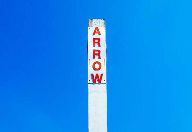 an arrow sign in the sky under a blue sky