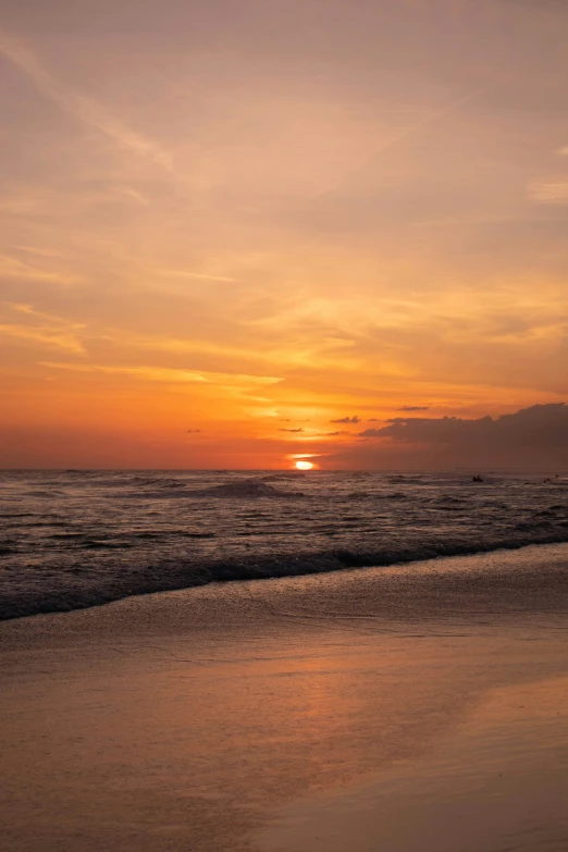 the ocean waves come to shore as the sun sets