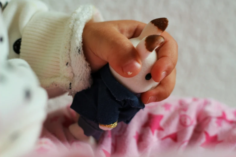 a baby holding soing small on it's finger