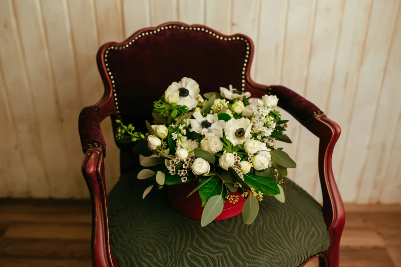 flowers in a vase is sitting on a chair