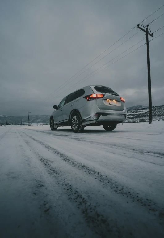 a car driving on the side of a road in the snow