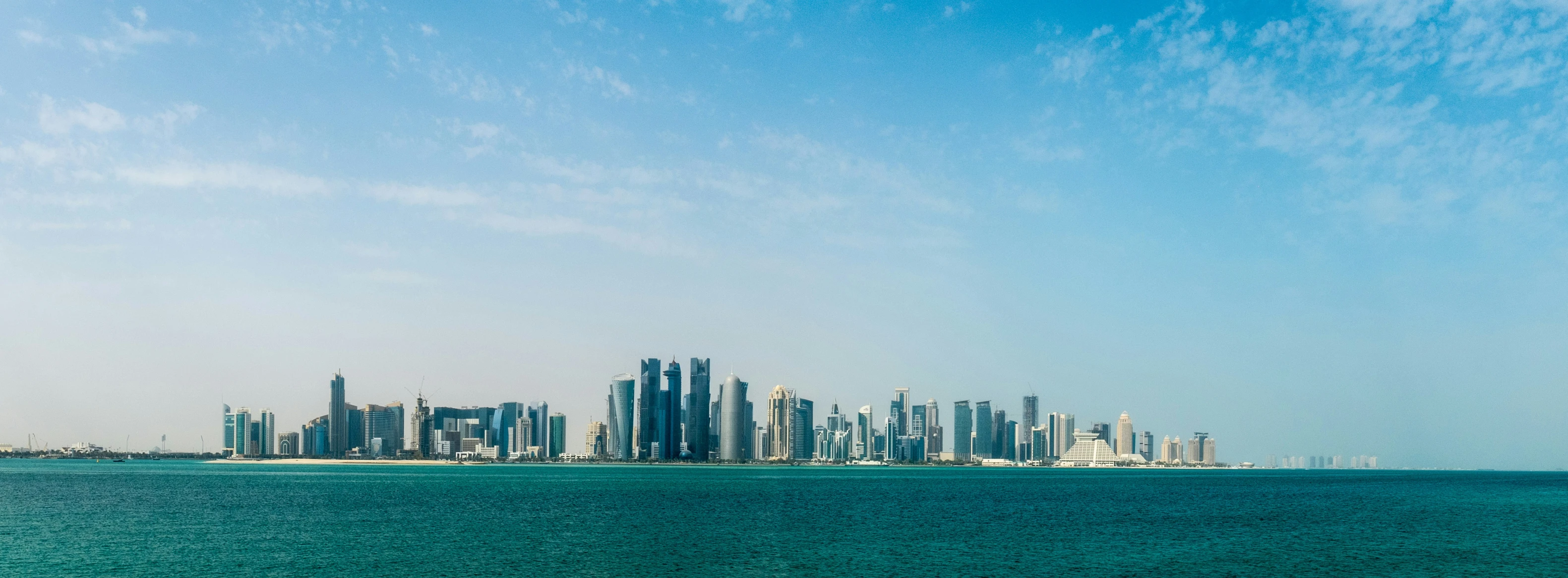 the skyline of a large city is shown over the ocean