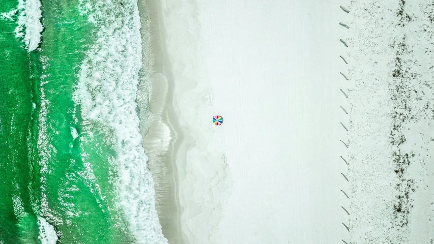 two people walking on the beach in the water