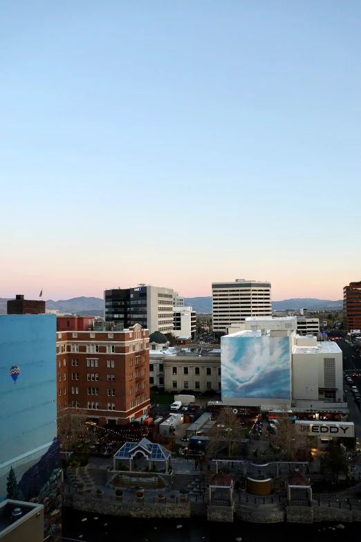 a city at twilight with skyscrs and a tv screen