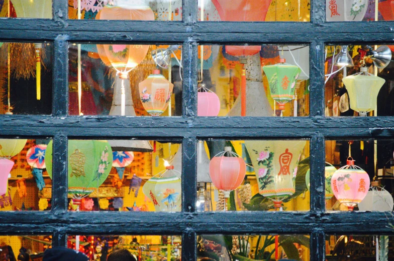 an old window displays many asian items with a small vase in the background