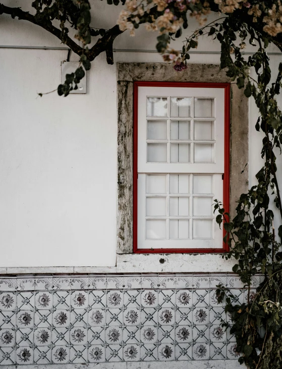 an old window is next to a tile covered wall