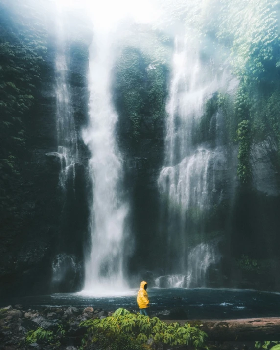 a person sitting next to a big waterfall