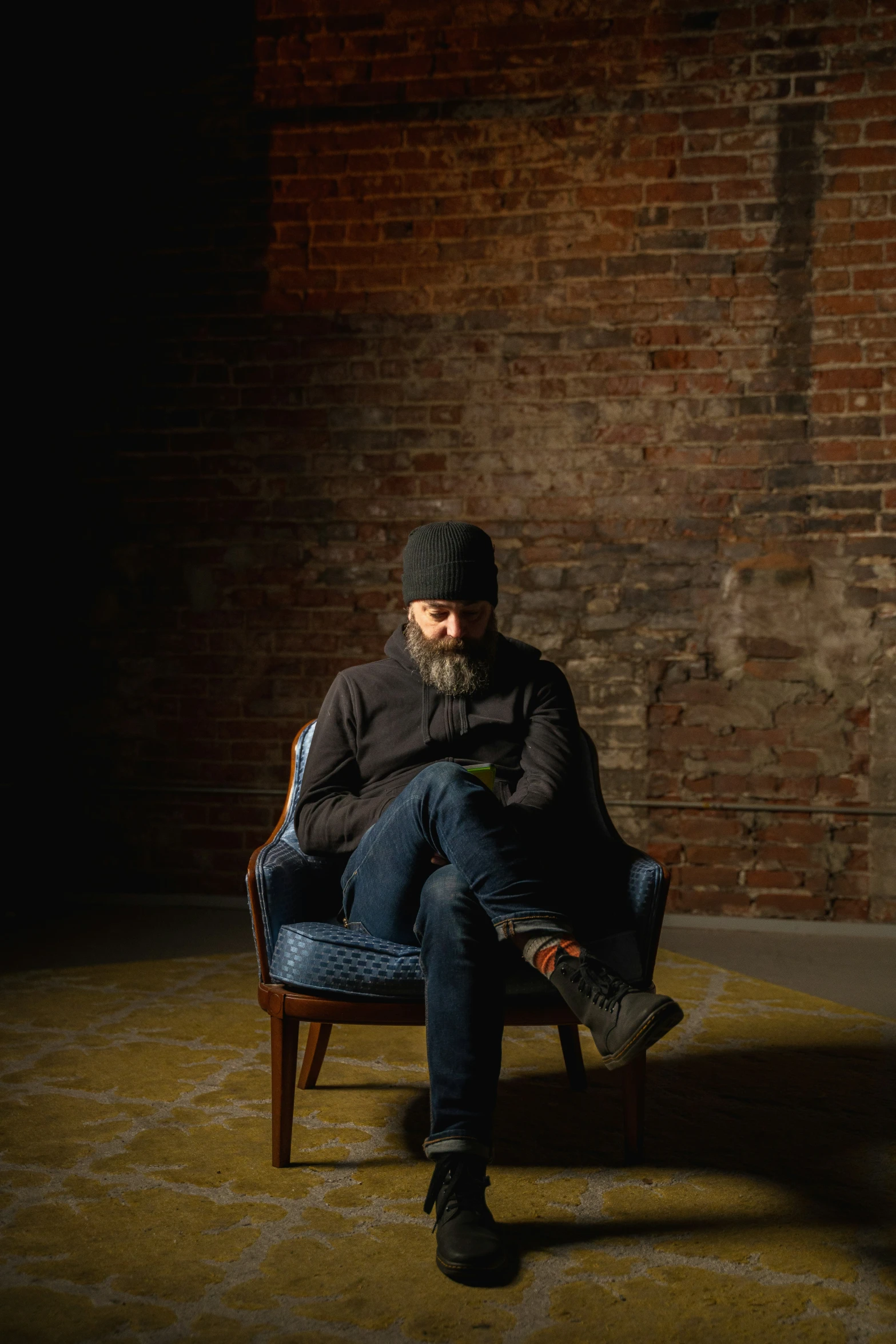 a person sitting on a chair while looking at a cell phone