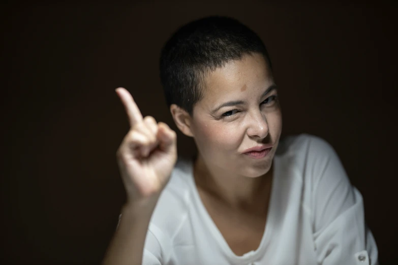 an asian boy giving the vulcan sign on a dark background