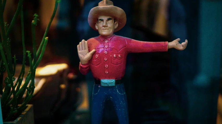 the toy cowboy is in front of some plants