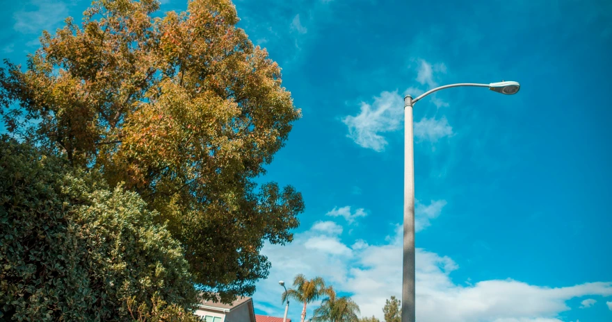 a light pole near a building under a blue sky