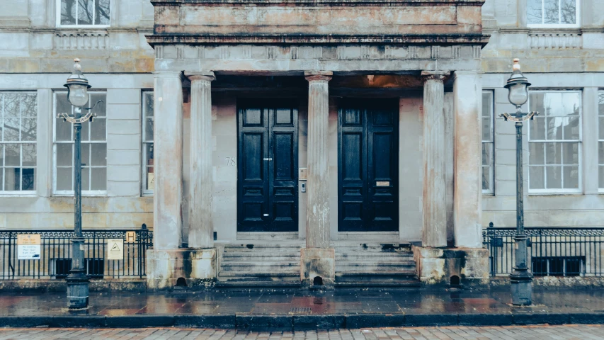 an old building with a door on a sidewalk