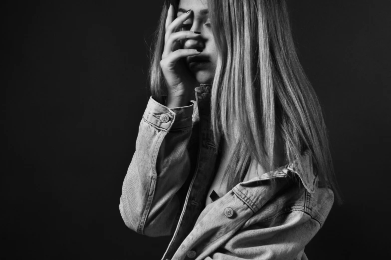 black and white pograph of woman with hand under mouth