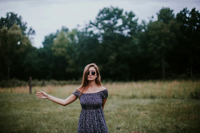 a woman standing in a field with her arms out